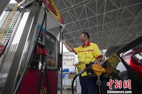 资料图：一加油站工作人员给车辆加油。中新社记者张云摄